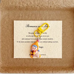 Cute cartoon girl keychain detail, lovely resin pendant with yellow clasp and backing card.