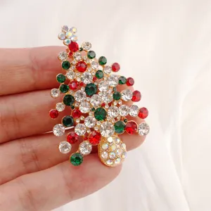 Close-up of a sparkling Christmas tree brooch with colorful rhinestones and gold-tone metal.