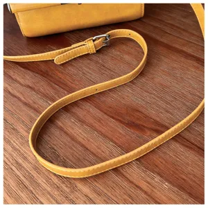 Yellow crossbody bag strap detail, premium PU leather and adjustable metal hardware.