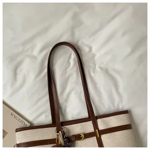 Large capacity canvas tote bag with brown leather trim and stylish buckle detail for daily use.