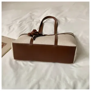 Large capacity canvas tote bag with brown leather contrast trim, stylish commuter shoulder bag.