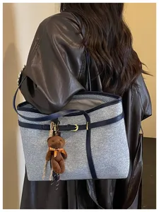 Large capacity denim tote bag with contrast leather trim and cute bear pendant for women.