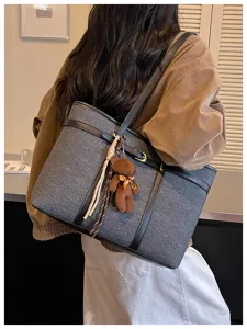Large capacity retro tote bag with teddy bear pendant, stylish commuter shoulder bag for women.