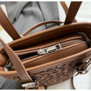 Gedetailleerd close-up van stijlvolle bruine luipaardprint bucketbag met zilveren rits.
