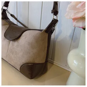 Close-up of the vintage shoulder bag detail, featuring brown leather and beige suede contrast.