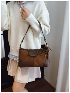 Close-up detail of the retro brown shoulder bag with charming wooden beads and chic flap design.