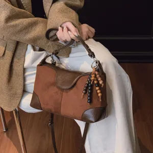 Retro brown suede shoulder bag for women, stylish commuting tote with chic wooden bead charm.