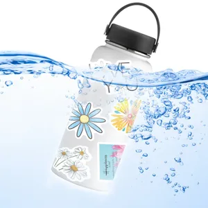 Bottiglia d'acqua bianca con adesivi di margherite estetiche e citazioni, dettaglio.
