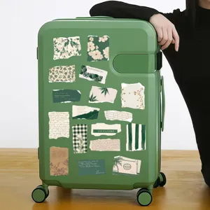 Green vintage suitcase decorated with aesthetic botanical torn-edge stickers and artistic patterns.