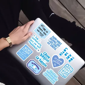 Detail shot of blue motivational quote stickers applied on a laptop for daily DIY crafts.