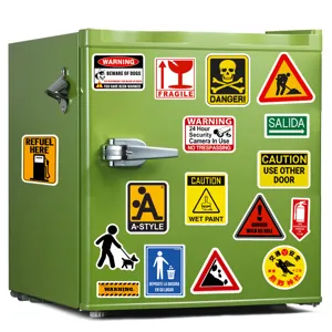 Mini refrigerador verde decorado con varias pegatinas de graffiti de advertencia coloridas.