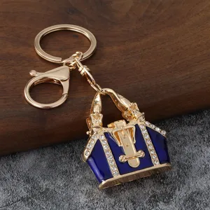 Porte-clés élégant mini sac à main métal émail bleu strass, anneau doré.