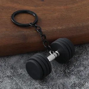 Primo piano di un portachiavi a forma di manubrio in metallo con pesi in silicone nero.
