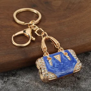 Close-up detail of luxury blue rhinestone handbag metal keychain pendant and keyring accessory.