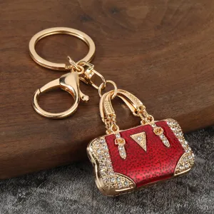 Close-up detail of luxury red enamel rhinestone handbag keychain metal charm pendant accessory.