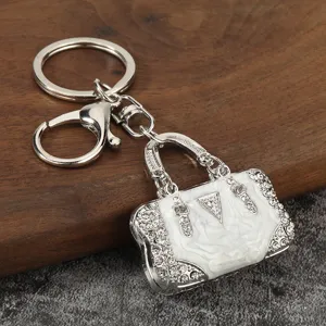 Exquisite rhinestone handbag keychain, metal alloy material with white dripping oil, great decor.