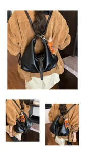 Detail shot of retro Korean style women black slouchy shoulder backpack with cute plush bear pendant.