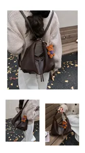 Detail shot of the vintage dark brown slouchy tote backpack featuring a cute plush bear charm.