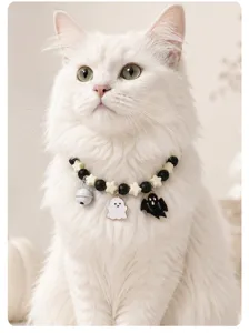 Detailaufnahme eines süßen Halloween Katzenhalsbands mit kleinen Geisterhängern für Haustiere.