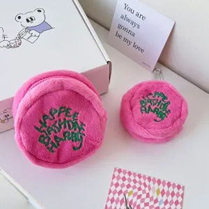 Pink plush round coin purse and cute mini earphone case with green embroidery text design.
