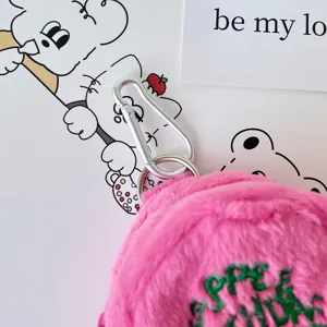 Pink plush coin purse detail with soft plush material, green embroidery, and silver keyring hook.