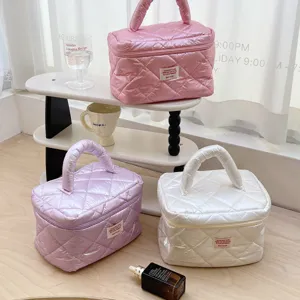 Quilted cosmetic bag detail, pearl gloss puffy fabric, portable makeup pouch and travel storage bag.