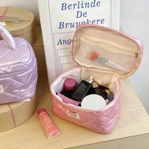 Pink puffer cosmetic bag quilted travel makeup pouch with handle and mesh pockets inside.