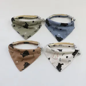 Close-up detail of cute pet cat bandana collar with bell and black cat print in multi colors.