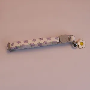 Detailansicht des lila Blumen Haustierhalsbands mit Katzenschnalle, Glocke und Blumenanhänger.