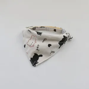 Pet cat bib collar detail view, cute cartoon pattern print with small bell accessory.