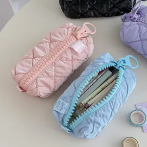 Large capacity puffer cosmetic bag and pencil case with oversized zipper for travel daily use.