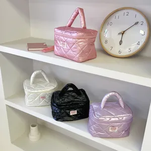 Detailed view of quilted cosmetic bags displayed on clean shelves with puffer texture.