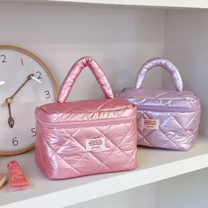 Detailed view of quilted shiny cosmetic makeup bag, portable travel toiletry storage pouch.