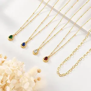 Gros plan détaillé de délicats colliers avec pendentifs en zircons de diverses couleurs.