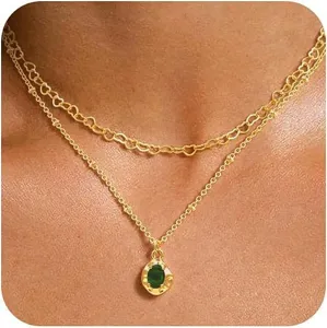 Gros plan détail du collier en or à double rangée avec chaîne cœur et pendentif zircon.