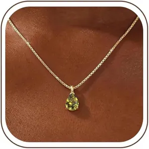 Close-up detail of a gold-plated box chain necklace with a pear-shaped green zircon pendant.