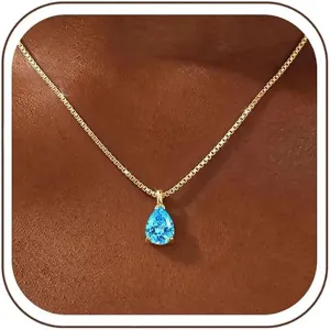 Close-up of a pear-cut blue cubic zirconia pendant necklace on a delicate gold box chain.
