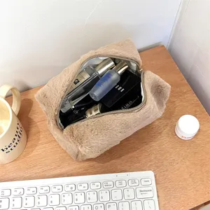 Detail shot of a plush cosmetic bag in a cozy aesthetic setup with makeup items inside.