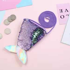 Detailed shot of the sequin mermaid tail coin purse with strap and coins on pink background.