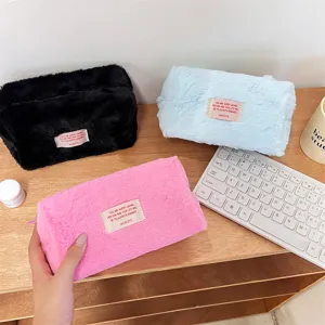 Plush makeup bag detail view, soft furry fabric surface texture, portable cosmetic storage pouch.
