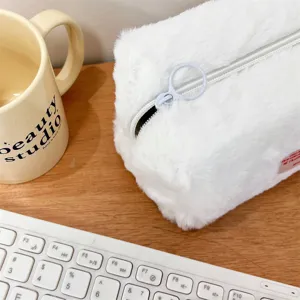 White fluffy plush cosmetic bag detail, soft fabric texture with zipper and ring puller.