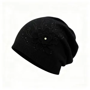 Black knit beanie hat featuring a 3D floral applique and sparkling rhinestone details.