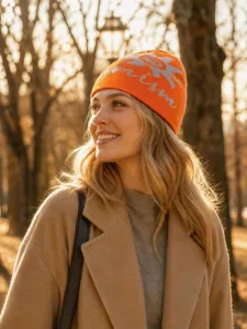 Orange knit beanie hat with sunflower pattern and optimism letter for autumn and winter.