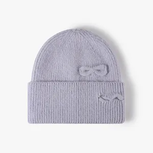 Close-up detail of the knit beanie showing soft rabbit hair texture and cute side bow.