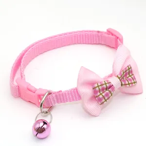 Cute pink pet collar close-up, featuring a plaid bow and a metallic bell for cats.