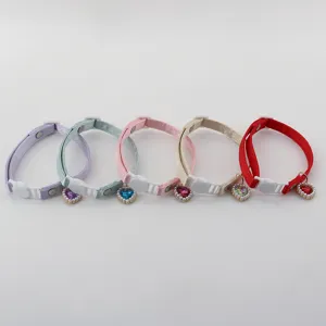 Close-up view of satin pet collars featuring sparkly heart crystal pendants and cute pearls.
