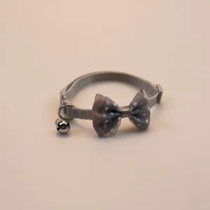 Detailed view of the grey polka dot pet collar, featuring a cute bow and a jingling bell.