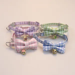 Detail view of cute plaid pet cat and dog collars featuring a lovely bow and bell in multi colors.