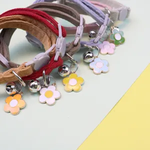 Corduroy pet collar detail showing cute flower pendant, silver bell and safe buckle design.