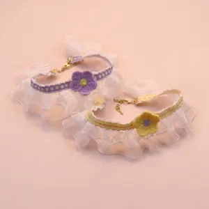 Detailed close-up of lace pet collar with cute knit flower, frill lace and metal adjustment chain.